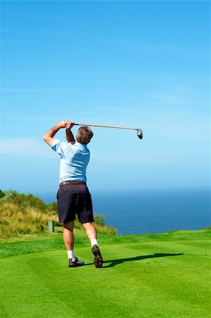 Senior male golfer playing golf from the tee box facing the ocean on a beautiful summer day Photographie de stock - Aubaine LD & Abonnement, Code: 400-04160928