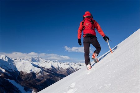 simsearch:400-04126574,k - A male climber , dressed in red, climbs down a snowy slope. Winter clear sky day. In background the Monte Rosa massif, Italy, Europe. Fotografie stock - Microstock e Abbonamento, Codice: 400-04161336