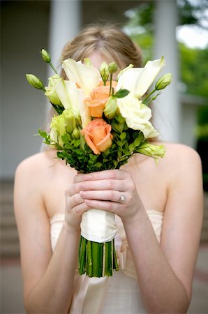 simsearch:400-03932395,k - Image of a bride holding her bouquet over her face Fotografie stock - Microstock e Abbonamento, Codice: 400-04161888