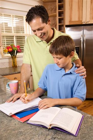 photos for a teenage student and a parent - Man helping young boy with homework.  Vertically framed shot. Stock Photo - Budget Royalty-Free & Subscription, Code: 400-04162391