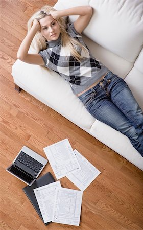 High angle view of a young woman frustrated while doing paperwork. Vertical shot. Stock Photo - Budget Royalty-Free & Subscription, Code: 400-04162428