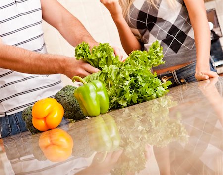 simsearch:400-04162443,k - Cropped view of a young couple stand behind a kitchen counter full of vegetables. Horizontal shot. Fotografie stock - Microstock e Abbonamento, Codice: 400-04162435