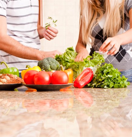 simsearch:400-04162443,k - Young couple pick through fresh vegetables behind a kitchen counter. Square shot. Fotografie stock - Microstock e Abbonamento, Codice: 400-04162441