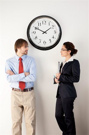 simsearch:400-04167566,k - Male and female businesspersons under clock. Vertically framed shot. Stockbilder - Microstock & Abonnement, Bildnummer: 400-04162544