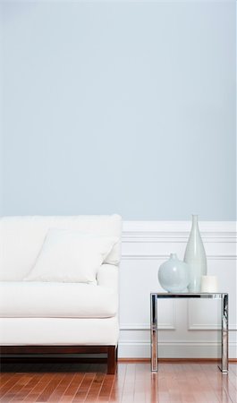 White sofa and glass end table with vases set against pale blue wall. Vertical shot. Fotografie stock - Microstock e Abbonamento, Codice: 400-04162555