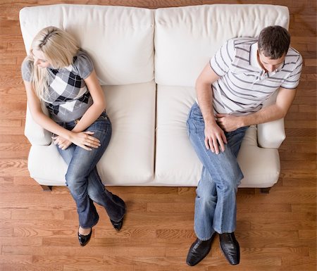 Man and a woman sit distantly on the ends of a cream colored love seat. Horizontal shot. Stock Photo - Budget Royalty-Free & Subscription, Code: 400-04162575