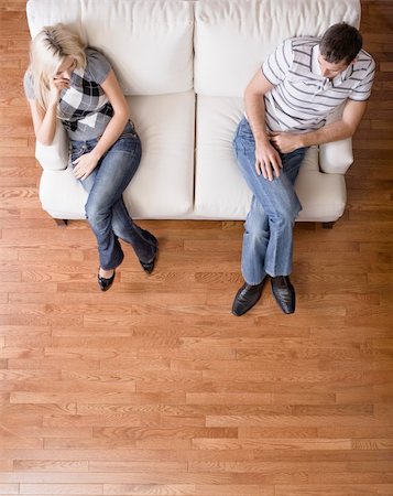 Man and a woman sit distantly on the ends of a cream colored love seat. Vertical shot. Stock Photo - Budget Royalty-Free & Subscription, Code: 400-04162573