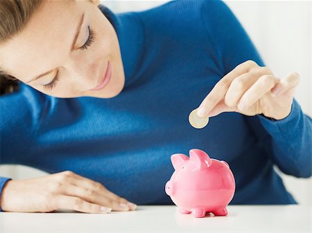 woman putting 1 euro in small piggy bank. Selective focus, Copy space Stock Photo - Budget Royalty-Free & Subscription, Code: 400-04163530