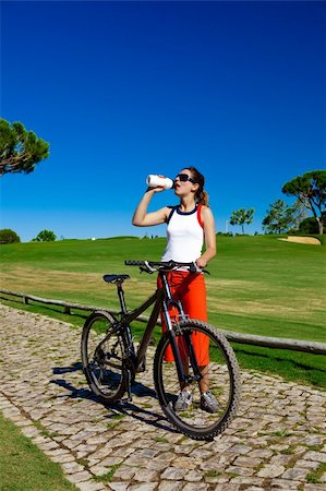 Young beautiful woman resting and drinking water after riding a bike Stock Photo - Budget Royalty-Free & Subscription, Code: 400-04174019