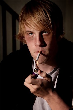 Depressed young man smoking in a tenement hovel Stock Photo - Budget Royalty-Free & Subscription, Code: 400-04175141