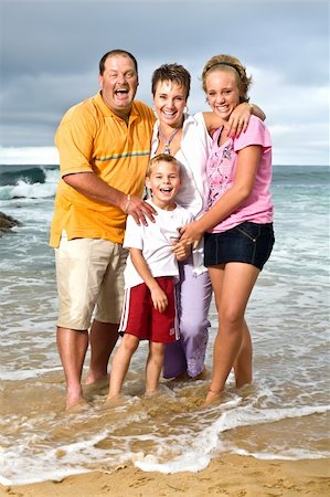 simsearch:400-04062793,k - A happy family of mom, dad, sister and brother standing in the sea on their day at the beach Photographie de stock - Aubaine LD & Abonnement, Code: 400-04176566