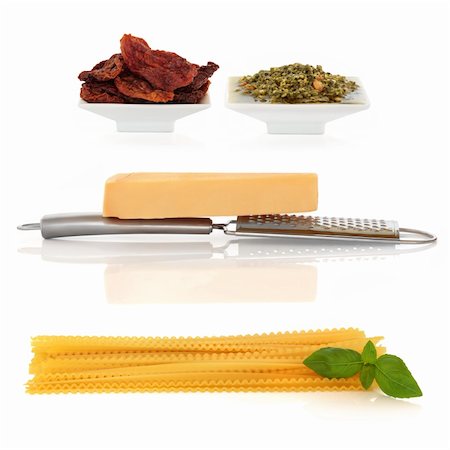 séché (soleil) - Italian food ingredients of pasta with basil herb,  parmesan cheese and grater, sun dried tomatoes and pesto sauce,  isolated over white background. Photographie de stock - Aubaine LD & Abonnement, Code: 400-04178535