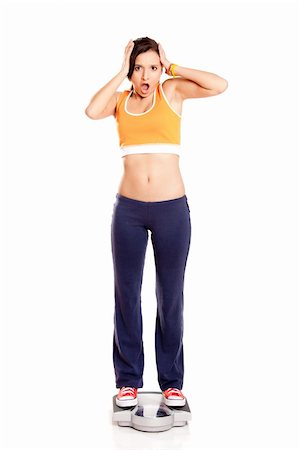 Portrait of a beautiful athletic girl checking her weight, isolated on white Stock Photo - Budget Royalty-Free & Subscription, Code: 400-04178664