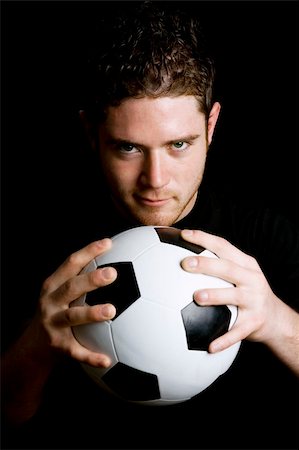 Stock image of man holding soccer ball over dark background Stock Photo - Budget Royalty-Free & Subscription, Code: 400-04179374