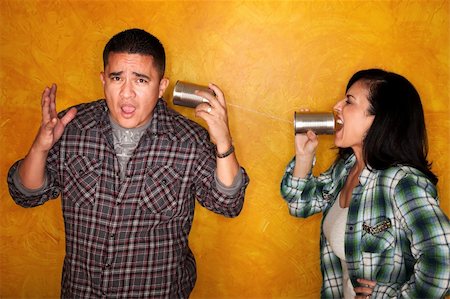 Attractive Hispanic man and woman communicate through tin cans Stock Photo - Budget Royalty-Free & Subscription, Code: 400-04179558