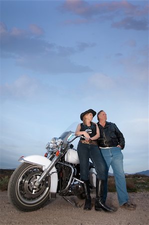 Man and woman with motorcycle in the desert at dusk Stock Photo - Budget Royalty-Free & Subscription, Code: 400-04179575