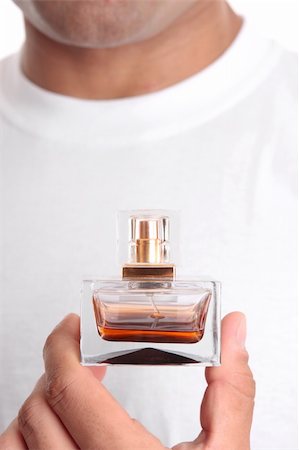 A closeup of a man holding perfume or aftershave.   Closeup.  Focus to bottle only. Stock Photo - Budget Royalty-Free & Subscription, Code: 400-04170853