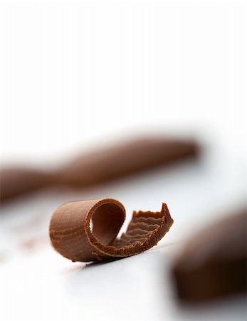 decoration curl - Close-up facture of a curl of chocolate on white with a piece of chocolate at the background Stock Photo - Budget Royalty-Free & Subscription, Code: 400-04171097