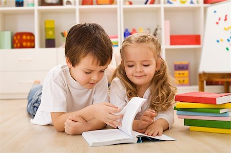 daycare on floor - School boy laying on the floor teaching and showing her sister how to read Stock Photo - Budget Royalty-Free & Subscription, Code: 400-04173000