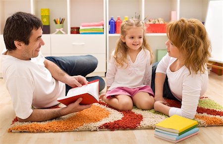 simsearch:400-04131892,k - Happy family reading a story laying on the floor in the kids room Stockbilder - Microstock & Abonnement, Bildnummer: 400-04173033