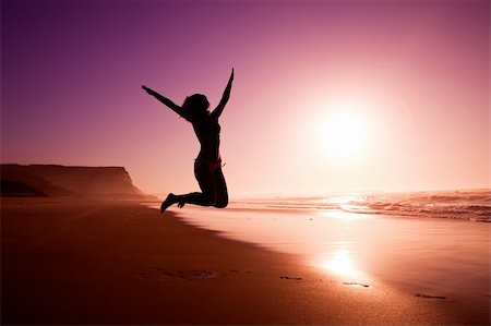 Picture of a female silhouette of a young girl jumping on the beach at the sunset Stock Photo - Budget Royalty-Free & Subscription, Code: 400-04173996