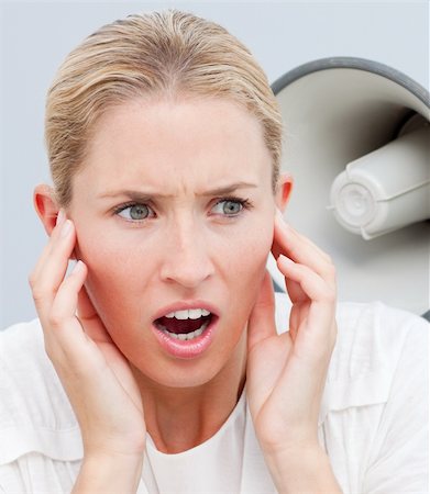 simsearch:400-09223567,k - Angry businesswoman listening to a megaphone in the office Stock Photo - Budget Royalty-Free & Subscription, Code: 400-04184246