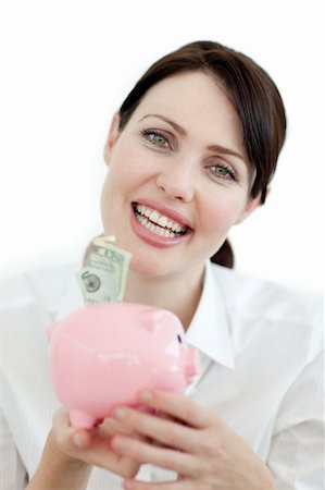 simsearch:400-05718322,k - Jolly businesswoman looking at the camera saving money a piggy bank Fotografie stock - Microstock e Abbonamento, Codice: 400-04184460