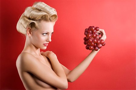 photo of model woman with grapes - nice shot of Beautiful naked blond woman over red background looking a red grape Stock Photo - Budget Royalty-Free & Subscription, Code: 400-04184507