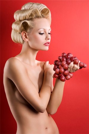 photo of model woman with grapes - Beautiful naked blond woman over red background with some red grape Stock Photo - Budget Royalty-Free & Subscription, Code: 400-04184510