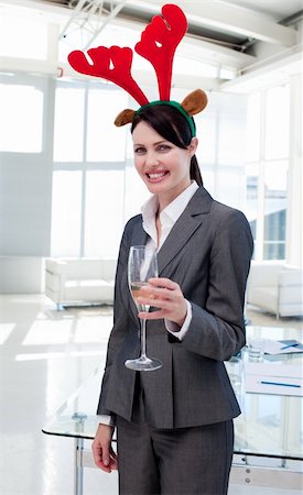 Smiling businesswoman with a novelty Christmas hat toasting with Champagne in the office Stock Photo - Budget Royalty-Free & Subscription, Code: 400-04184832