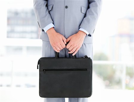 financial portfolio - Mysterious businessman holding a briefcase in the office Stock Photo - Budget Royalty-Free & Subscription, Code: 400-04185684