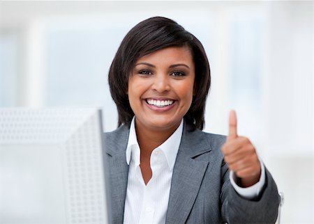 simsearch:400-04187842,k - Happy businesswoman with a thumb up working at a computer in the office Stock Photo - Budget Royalty-Free & Subscription, Code: 400-04185717