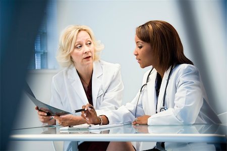Female doctors discussing patient x ray films. Stock Photo - Budget Royalty-Free & Subscription, Code: 400-04186272