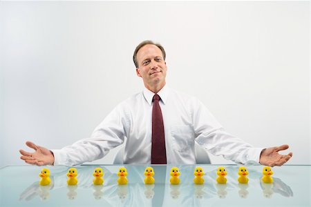 simsearch:400-04186486,k - Portrait of middle aged  Caucasian businessman sitting at desk with ducks in a row. Stock Photo - Budget Royalty-Free & Subscription, Code: 400-04186445
