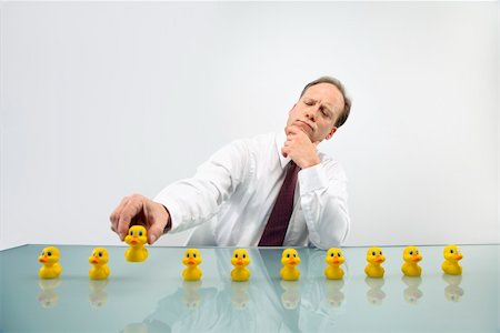 simsearch:400-04186486,k - Portrait of middle aged  Caucasian businessman sitting at desk with ducks in a row. Stock Photo - Budget Royalty-Free & Subscription, Code: 400-04186448