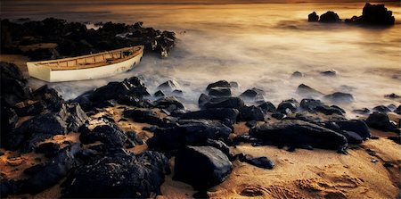 simsearch:400-08254225,k - Rowboat is washed up on rocks at sunset Stock Photo - Budget Royalty-Free & Subscription, Code: 400-04186619