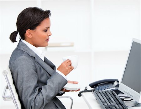 simsearch:400-04187842,k - Attractive businesswoman drinking a coffe while working at a computer in the office Stock Photo - Budget Royalty-Free & Subscription, Code: 400-04186972