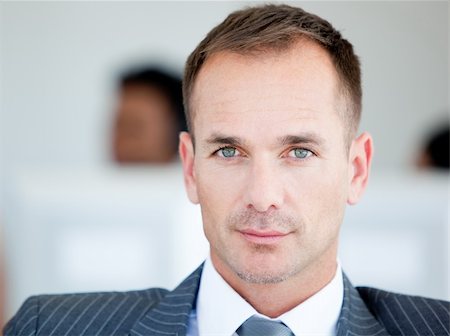 Handsome businessman looking at the camera in the office Stock Photo - Budget Royalty-Free & Subscription, Code: 400-04186981