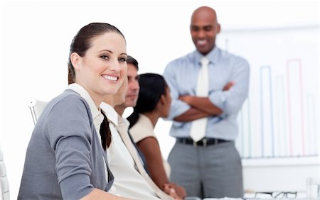 Smiling businesswoman looking at the camera during a meeting with her team in a company Stock Photo - Budget Royalty-Free & Subscription, Code: 400-04187054