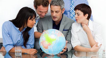 simsearch:400-04187718,k - International business people looking at a terrestrial globe in the office Foto de stock - Royalty-Free Super Valor e Assinatura, Número: 400-04187716