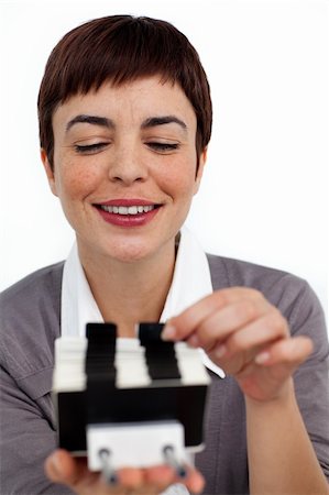 Confident businesswoman consulting a business card holder against a white background Stock Photo - Budget Royalty-Free & Subscription, Code: 400-04188014