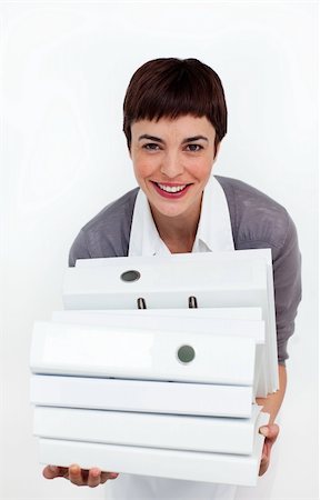 suited person holding paper up - Smiling businesswoman putting a stack of folders on a desk against a white background Stock Photo - Budget Royalty-Free & Subscription, Code: 400-04188049