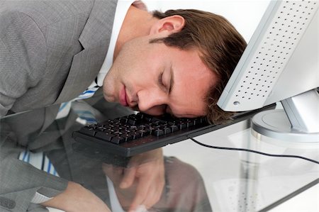 executive sleeping desk - Close-ep of a tired businessman sleeping on his desk against a white background Stock Photo - Budget Royalty-Free & Subscription, Code: 400-04188055