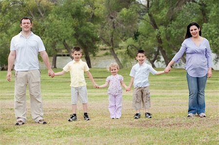 simsearch:400-04216385,k - Happy family holding hands on a natural background Foto de stock - Super Valor sin royalties y Suscripción, Código: 400-04188362