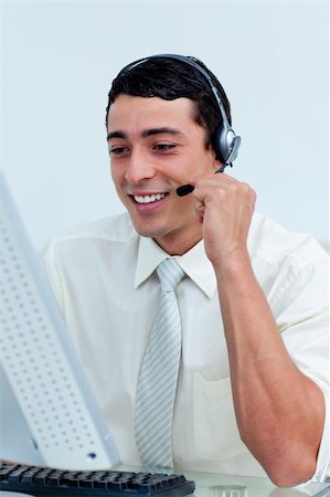 simsearch:400-04188205,k - Young businessman using headset working at a computer Stock Photo - Budget Royalty-Free & Subscription, Code: 400-04188454
