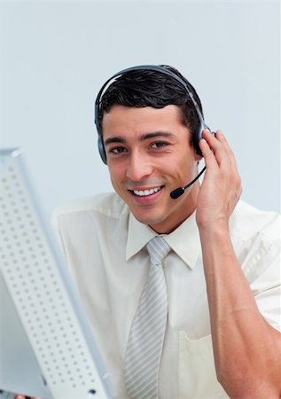 simsearch:400-04352175,k - Assertive businessman using headset working at a computer Stock Photo - Budget Royalty-Free & Subscription, Code: 400-04188453