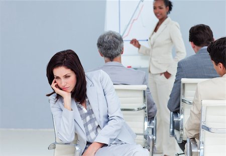 Bored young businesswoman at a presentation with her colleagues Foto de stock - Super Valor sin royalties y Suscripción, Código: 400-04188506