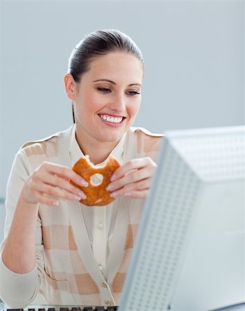 Portrait of a caucasian businesswoman eating donnuts in her office in a company Stock Photo - Budget Royalty-Free & Subscription, Code: 400-04188632