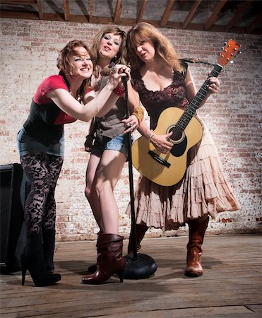 All-girl trio performing in stylish clothing at a warehouse Stock Photo - Budget Royalty-Free & Subscription, Code: 400-04188841