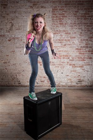 simsearch:400-04197216,k - Young punk rocker on a speaker in front of a brick background Photographie de stock - Aubaine LD & Abonnement, Code: 400-04188843